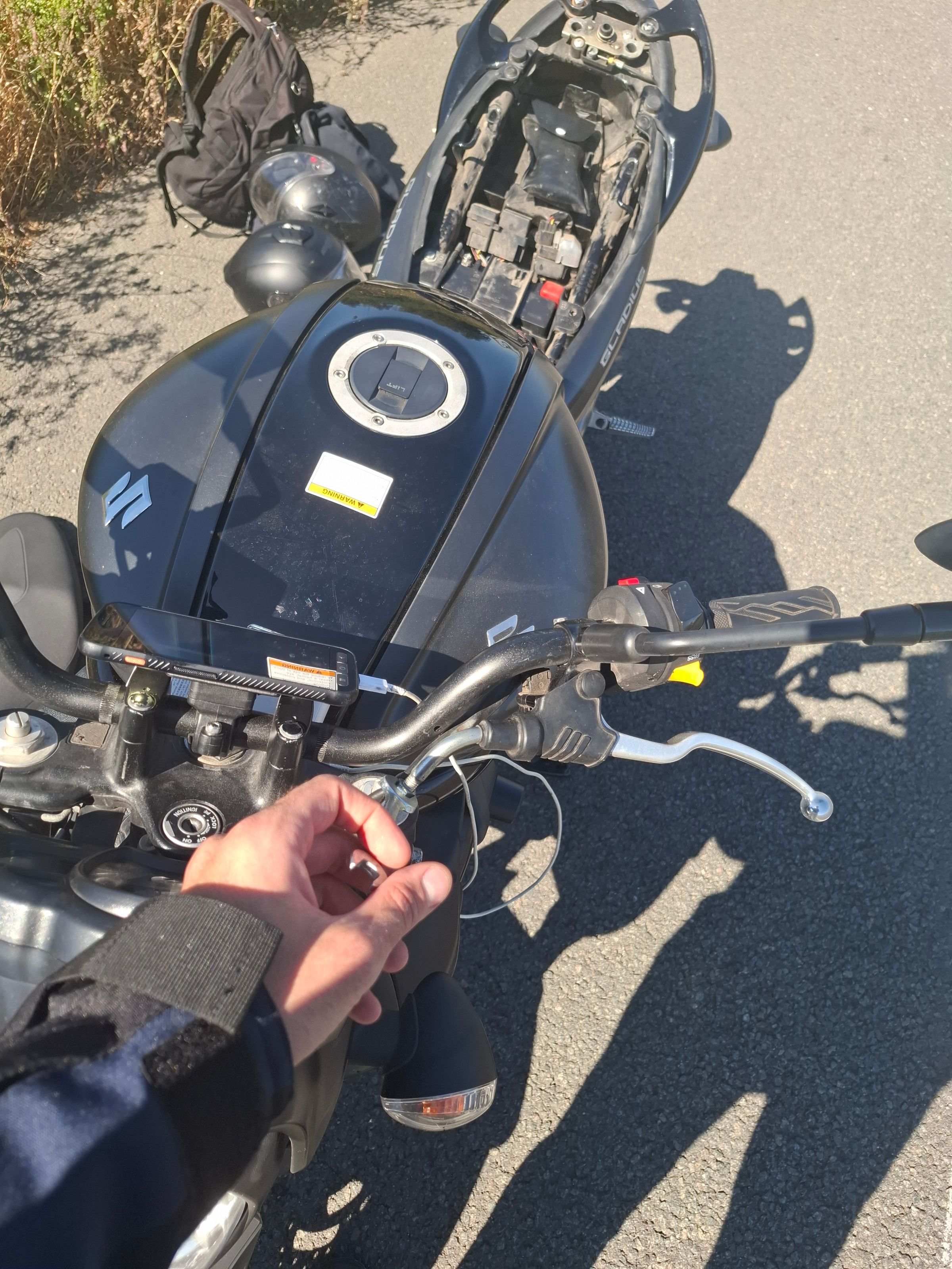 Adjusting the clutch cable with a spanner from the toolkit in the seat